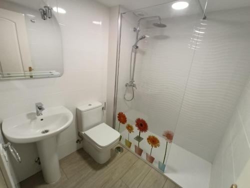 y baño con aseo, lavabo y ducha. en Frontbeach apartment in los Boliches, en Fuengirola