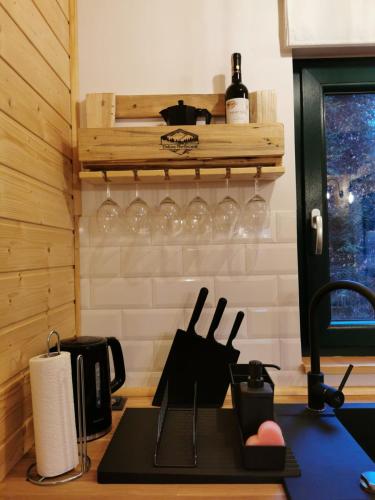 a kitchen with a counter with wine glasses on a shelf at Domki Wisła Dolina Partecznik in Wisła