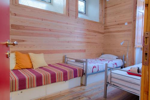 2 camas en una habitación con paredes de madera en This Is Lisbon Hostel, en Lisboa