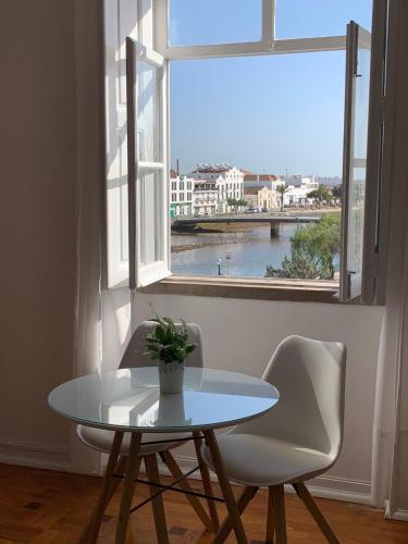 a table and chairs in a room with a window at Formosa Guest House in Tavira