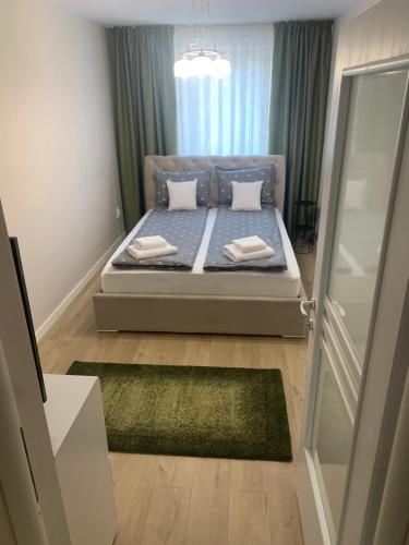 una camera da letto con letto con lenzuola e cuscini blu di Apartament Izabella a Topliţa