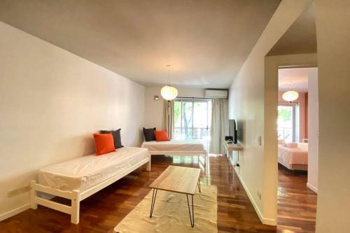 Sala de estar con 2 camas y mesa en Exclusivo Loft En Recoleta Zona Clinicas Y Avenidas en Buenos Aires