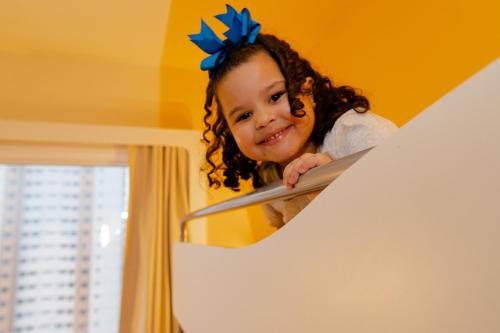 a little girl is looking at herself in a mirror at ibis budget Sao Caetano in São Caetano do Sul