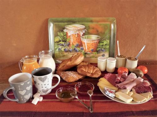- une table avec un plateau de produits pour le petit-déjeuner et des boissons dans l'établissement Aux 3 marteaux, à Soppe-le-Haut