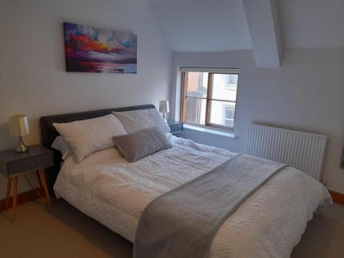 a bedroom with a white bed with a window at Travellers Rest Apartment in Beverley