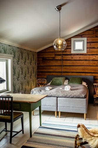 a bedroom with a bed and a wooden wall at Vanha pappila Hetki Oy in Ähtäri