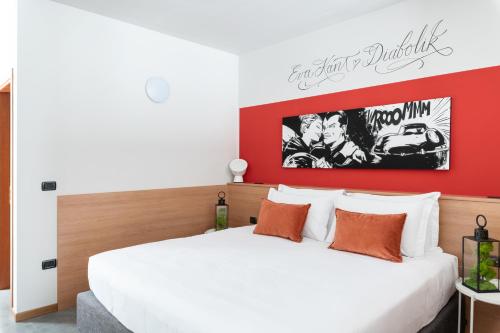 a bedroom with a white bed and a red wall at Hotel Borgo Brianteo in Ponte San Pietro