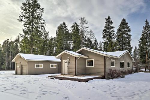 a home in the snow with trees in the background at Columbia Falls Private Retreat Pool Table and Deck! in Columbia Falls