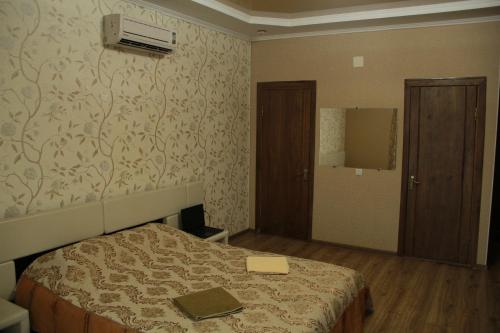 a bedroom with a bed with a book on it at Kristall Hotel in Bosteri