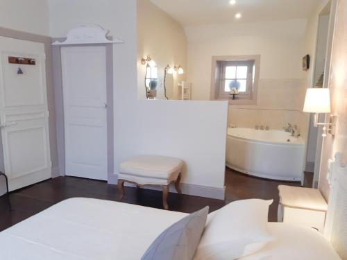 a bathroom with a tub and a toilet and a sink at Chambres d'Hotes Le 1900 in Val Couesnon