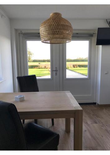 a dining room with a table and a large window at B&B De Spiegel - Genieten van rust en ruimte in Cothen