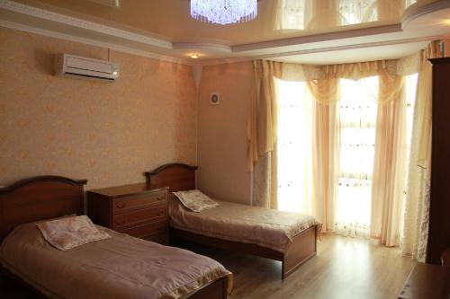 a bedroom with two beds and a window at Kristall Hotel in Bosteri