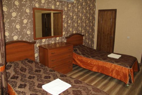 a hotel room with two beds and a mirror at Kristall Hotel in Bosteri