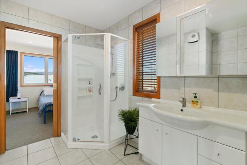 a white bathroom with a sink and a shower at Southern Belle - Cromwell Holiday Home in Cromwell