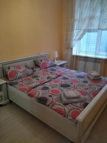 a bedroom with a bed with a red and gray bedspread at Apartments comfortablе in Chernivtsi