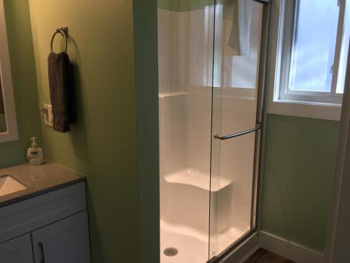 a shower with a glass door in a bathroom at Brookside Cottages in Waynesville