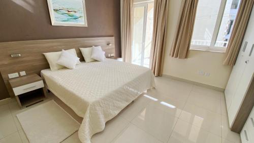 ein Schlafzimmer mit einem Bett und einem Fenster in der Unterkunft Vista Point - Cast Renting in Msida