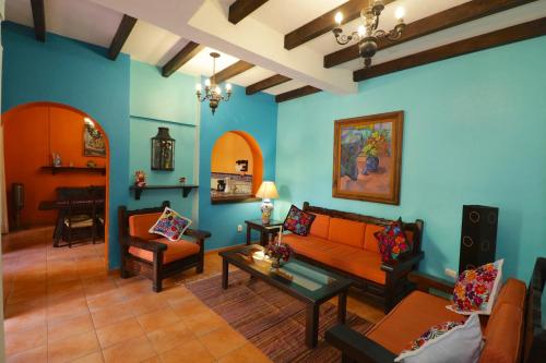 a living room with blue walls and orange furniture at Casa Mia Suites in San Miguel de Allende