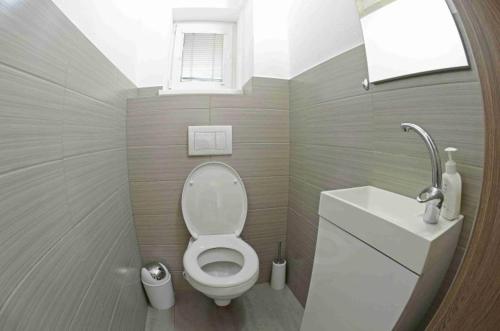 a small bathroom with a toilet and a sink at Chata Emily in Smižany