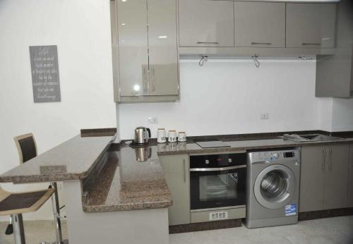 a kitchen with a stove and a washing machine at Amazing one Bedroom Apartment in Amman Elwebdah 3 in Amman