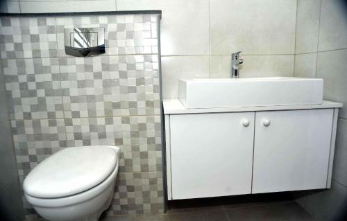 a bathroom with a white toilet and a sink at Amazing one Bedroom Apartment in Amman Elwebdah 6 in Amman