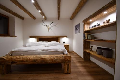 a bedroom with a bed in a room with wooden floors at Chalet Apartments Maštal in Železná Ruda