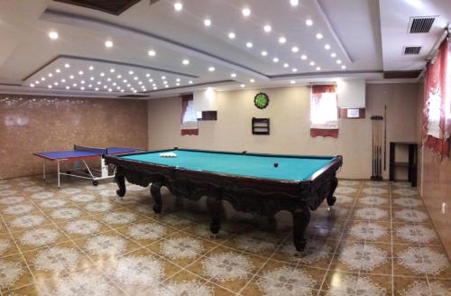 a pool table in a room with two ping pong tables at Kristall Hotel in Bosteri