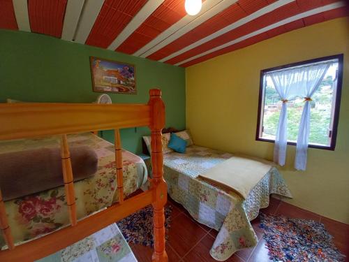 a bedroom with a bunk bed and a window at Chalés Encantos de Cunha Azul in Cunha