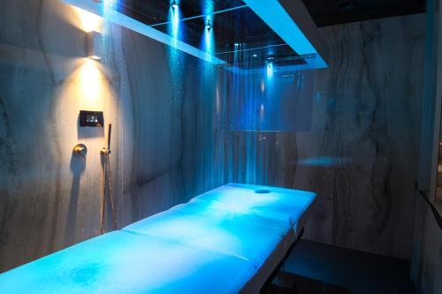 a room with a bed with blue lights in it at Hotel Sanglier in Durbuy