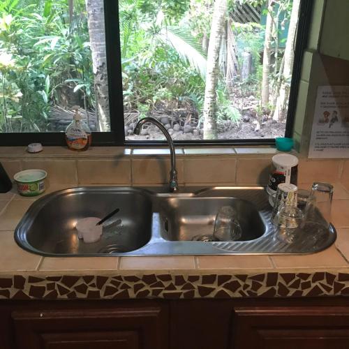 a stainless steel sink in a kitchen with a window at Chosa Manglar Suites & Cabins in Puerto Jiménez