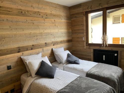 deux lits dans une chambre aux murs en bois dans l'établissement A place 2 be, Megève centre, à Megève