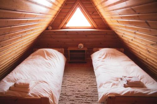 a bedroom with two beds in a log cabin at Krasna Chata Maniowy in Maniowy
