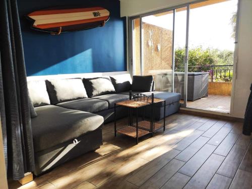 un salon avec un canapé et une grande fenêtre dans l'établissement Superbe T1 neuf avec vue mer sur Marinella, à Ajaccio