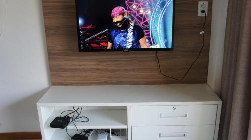 a flat screen tv sitting on top of a cabinet at Imbassai Summer Flats Village in Imbassai