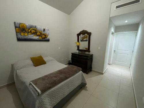 1 dormitorio con cama, tocador y espejo en CASA PONIENTE, en Hermosillo