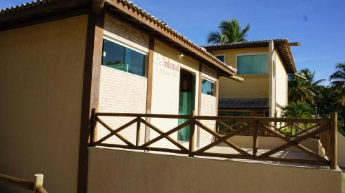 a building with a balcony with a wooden fence at Imbassai Summer Flats Village in Imbassai