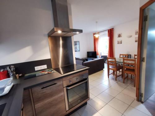 Il comprend une cuisine équipée d'une cuisinière. - un four supérieur à côté d'un salon dans l'établissement Appartements Cancale, à Cancale