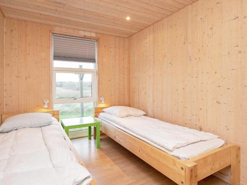 two beds in a room with wooden walls at Luxury Retreat in Gronhoj-By Traum in Løkken