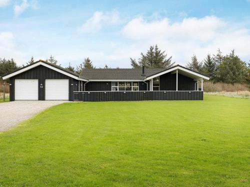 a black house with a large green yard at Luxury Retreat in Gronhoj-By Traum in Løkken