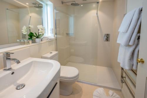 a bathroom with a sink and a toilet and a shower at One Holyrood Hotel & Cafe in Newport