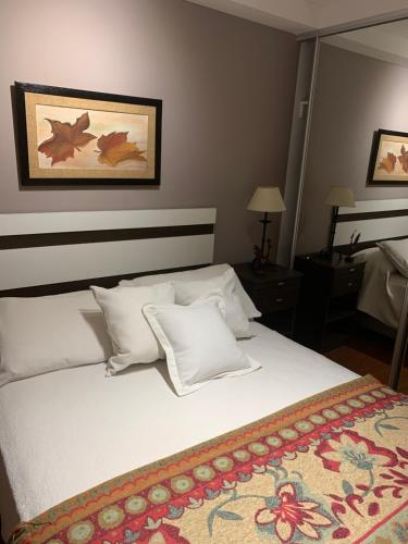 - une chambre avec un lit doté de draps et d'oreillers blancs dans l'établissement Departamento Ohiggins II, à Salta
