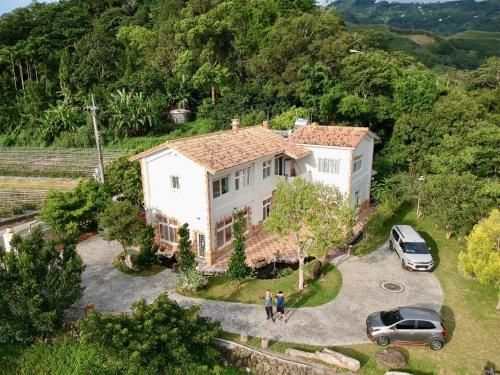 an aerial view of a house with two cars parked at The house behind stream in Dahu