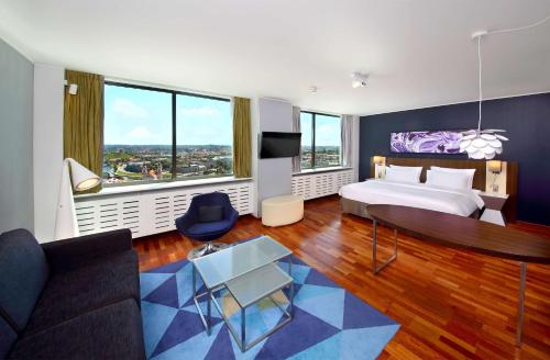 a hotel room with a bed and a couch at Radisson Blu Hotel Lietuva in Vilnius