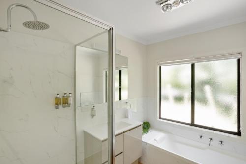 a bathroom with a shower and a sink and a mirror at Tyntynder Garden Cottage 1 in Bright