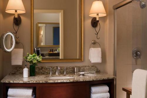 a bathroom with a sink and a mirror at River Terrace Inn, a Noble House Hotel in Napa