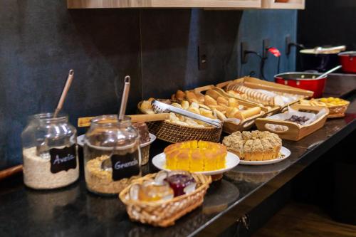 a counter with many different types of pastries and desserts at ibis Styles Curitiba Aeroporto in São José dos Pinhais