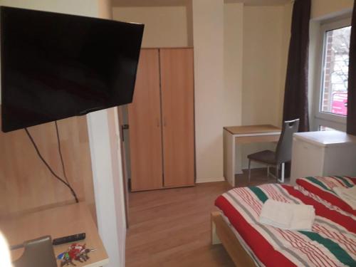 una camera con letto e TV a schermo piatto di City Boardinghouse Alsdorf ad Alsdorf