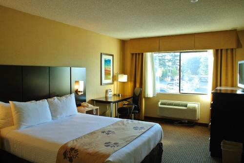 シータックにあるベスト ウエスタン シアトル エアポート ホテルの大きなベッドと窓が備わるホテルルームです。