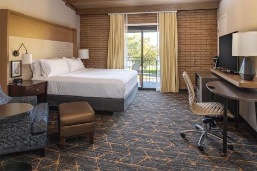 a hotel room with a bed and a desk at Holiday Inn Richland on the River by IHG in Richland