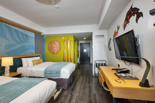 a hotel room with two beds and a flat screen tv at Skwachàys Lodge in Vancouver